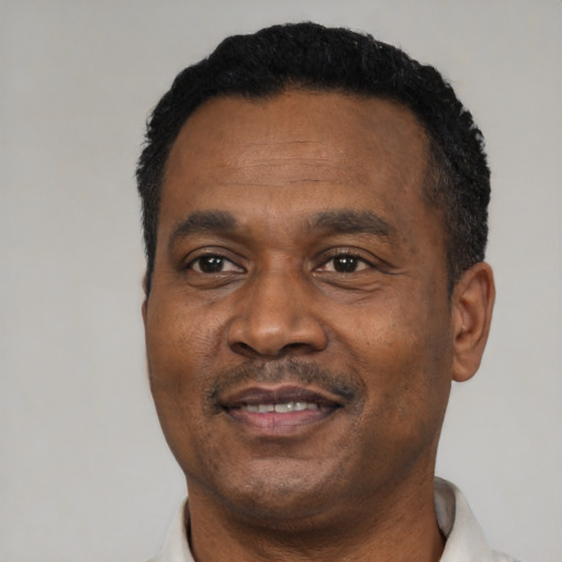 Joyful black adult male with short  black hair and brown eyes
