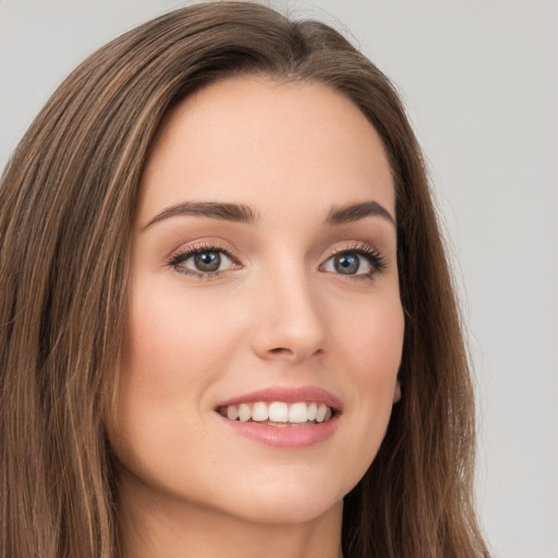 Joyful white young-adult female with long  brown hair and green eyes