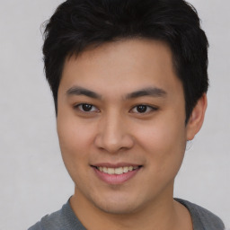 Joyful asian young-adult male with short  brown hair and brown eyes