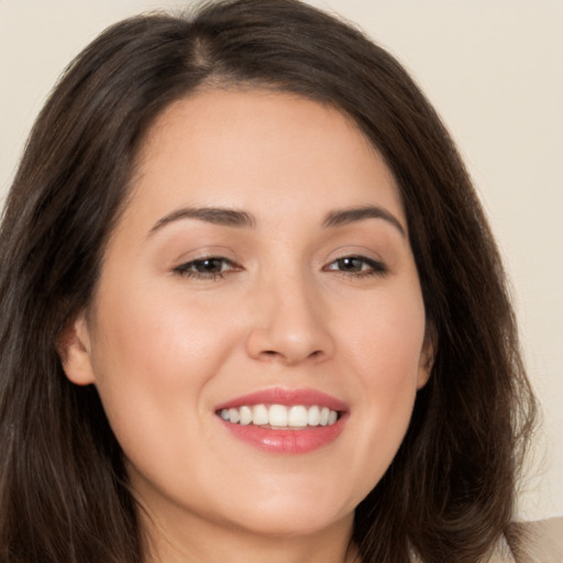 Joyful white young-adult female with long  brown hair and brown eyes