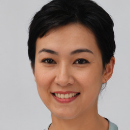 Joyful asian young-adult female with short  black hair and brown eyes