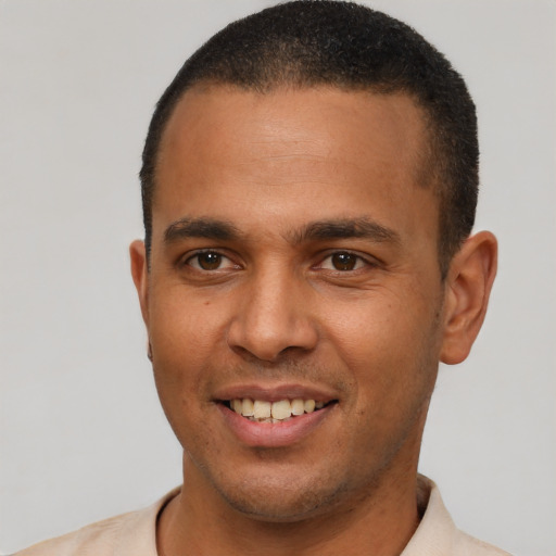 Joyful latino young-adult male with short  brown hair and brown eyes