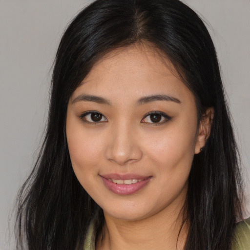 Joyful asian young-adult female with long  brown hair and brown eyes
