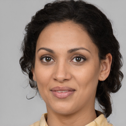 Joyful latino adult female with medium  brown hair and brown eyes