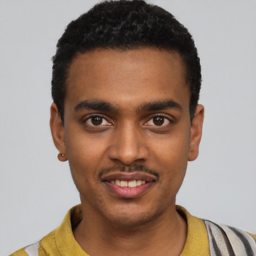 Joyful black young-adult male with short  black hair and brown eyes