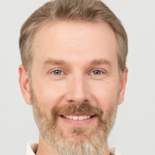 Joyful white adult male with short  brown hair and grey eyes