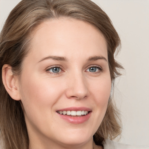 Joyful white young-adult female with long  brown hair and blue eyes