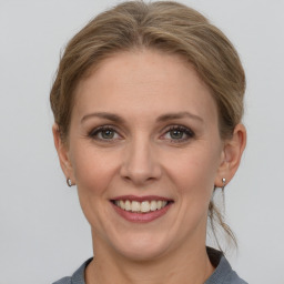 Joyful white adult female with medium  brown hair and grey eyes