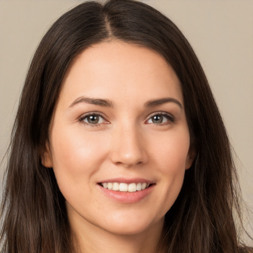 Joyful white young-adult female with long  brown hair and brown eyes