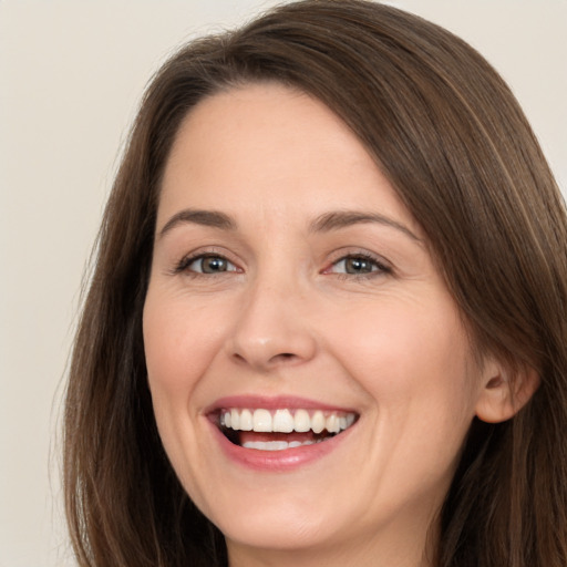 Joyful white young-adult female with long  brown hair and brown eyes