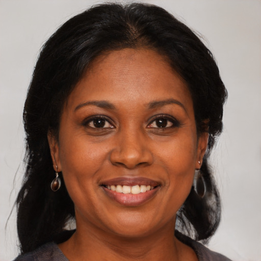 Joyful black adult female with medium  black hair and brown eyes