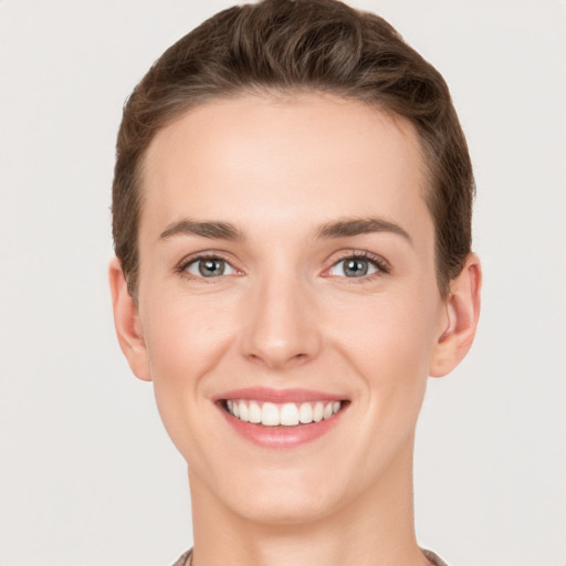 Joyful white young-adult female with short  brown hair and grey eyes