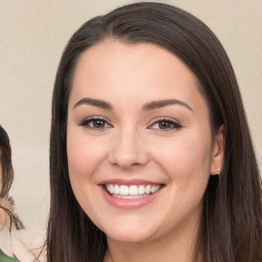 Joyful white young-adult female with long  brown hair and brown eyes