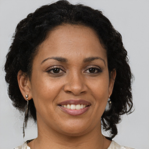 Joyful black adult female with medium  brown hair and brown eyes