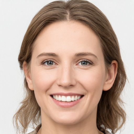 Joyful white young-adult female with medium  brown hair and grey eyes