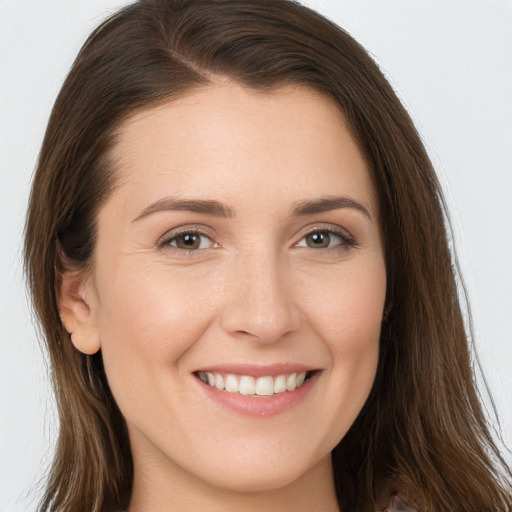 Joyful white young-adult female with long  brown hair and brown eyes