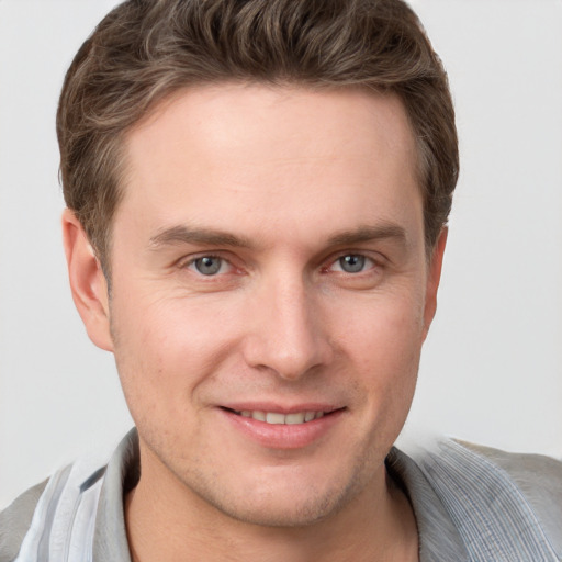 Joyful white young-adult male with short  brown hair and grey eyes