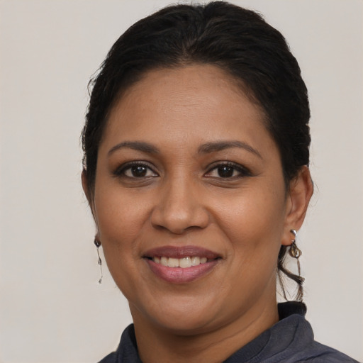 Joyful latino adult female with medium  brown hair and brown eyes