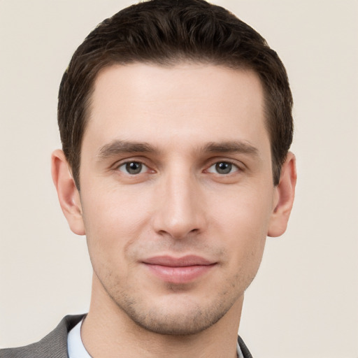 Joyful white young-adult male with short  brown hair and grey eyes