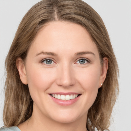 Joyful white young-adult female with medium  brown hair and grey eyes