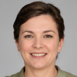 Joyful white young-adult female with short  brown hair and grey eyes