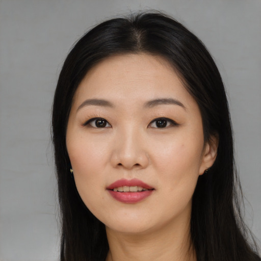 Joyful asian young-adult female with long  black hair and brown eyes
