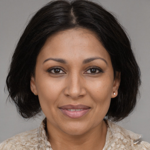 Joyful latino adult female with medium  brown hair and brown eyes