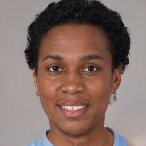 Joyful black young-adult female with short  black hair and brown eyes