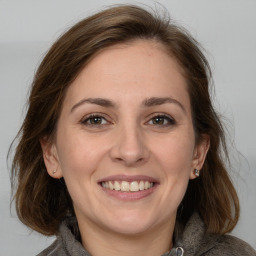 Joyful white adult female with medium  brown hair and grey eyes