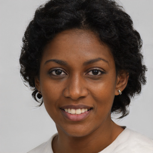 Joyful black young-adult female with short  black hair and brown eyes