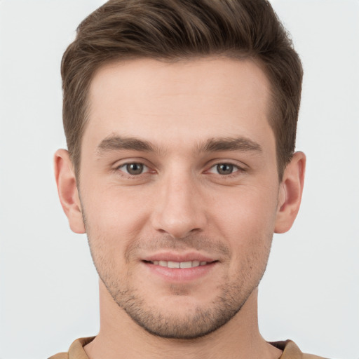 Joyful white young-adult male with short  brown hair and grey eyes