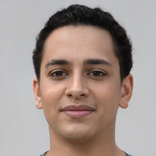 Joyful latino young-adult male with short  brown hair and brown eyes