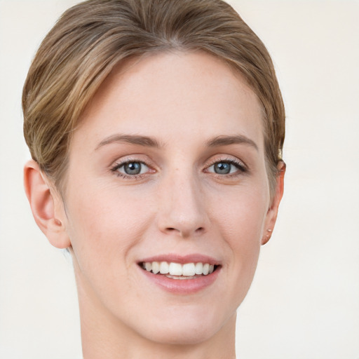 Joyful white young-adult female with short  brown hair and blue eyes