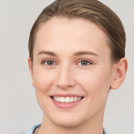 Joyful white young-adult female with short  brown hair and grey eyes