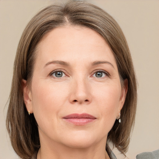 Joyful white adult female with medium  brown hair and grey eyes