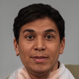 Joyful latino young-adult male with short  brown hair and brown eyes