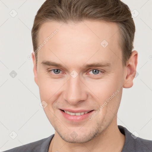 Joyful white young-adult male with short  brown hair and grey eyes