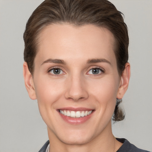 Joyful white young-adult female with short  brown hair and grey eyes