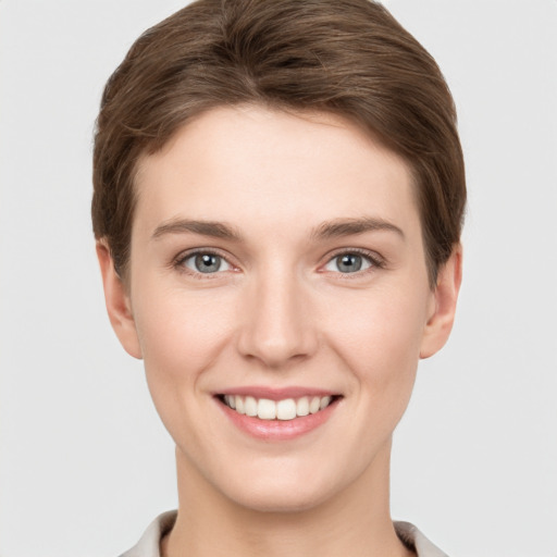 Joyful white young-adult female with short  brown hair and grey eyes