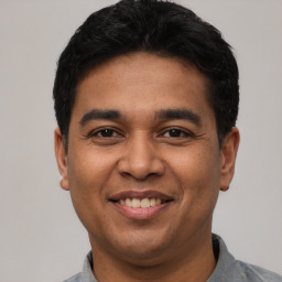 Joyful latino young-adult male with short  black hair and brown eyes