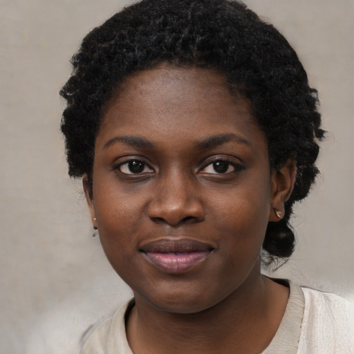 Joyful black young-adult female with short  black hair and brown eyes