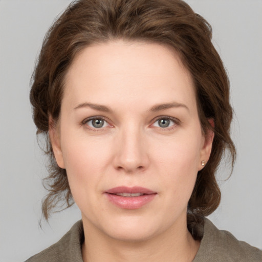 Joyful white young-adult female with medium  brown hair and grey eyes