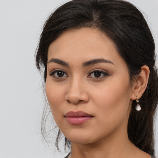 Joyful latino young-adult female with long  brown hair and brown eyes