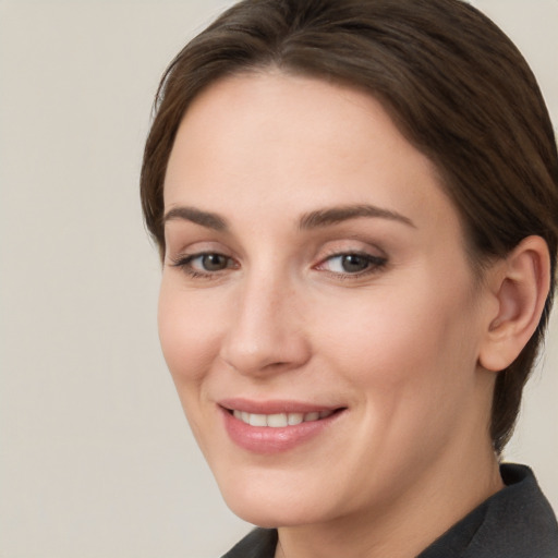 Joyful white young-adult female with medium  brown hair and grey eyes