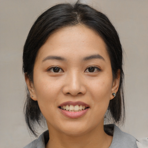 Joyful asian young-adult female with medium  black hair and brown eyes