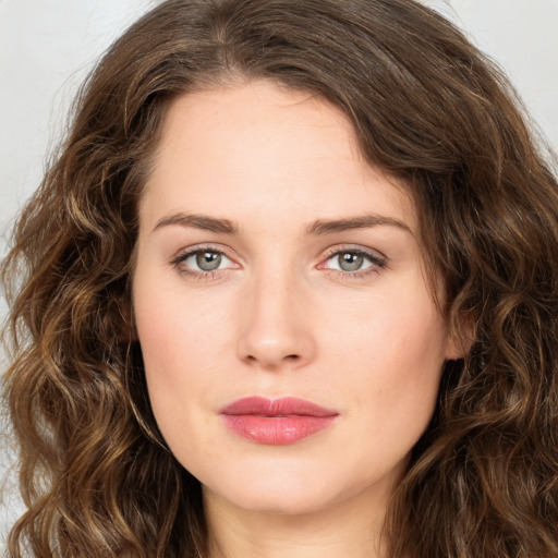 Joyful white young-adult female with long  brown hair and green eyes