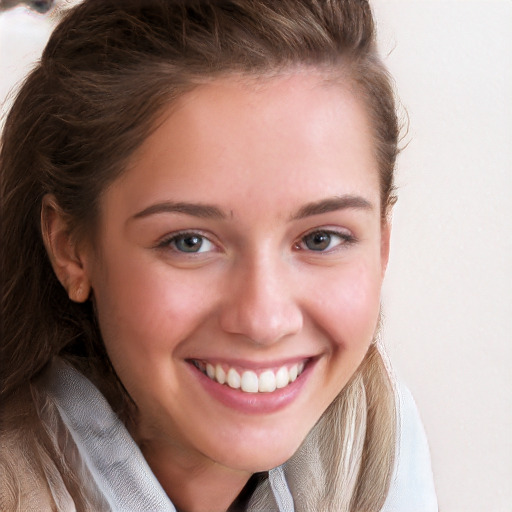 Joyful white young-adult female with long  brown hair and blue eyes