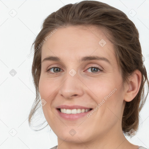 Joyful white young-adult female with medium  brown hair and grey eyes