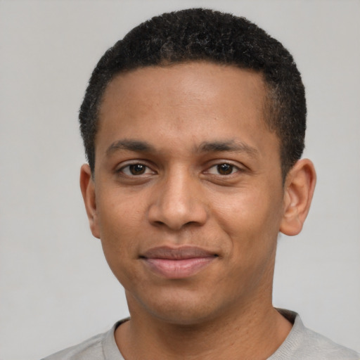 Joyful black young-adult male with short  black hair and brown eyes