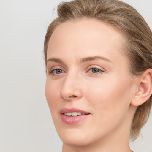 Joyful white young-adult female with medium  brown hair and blue eyes